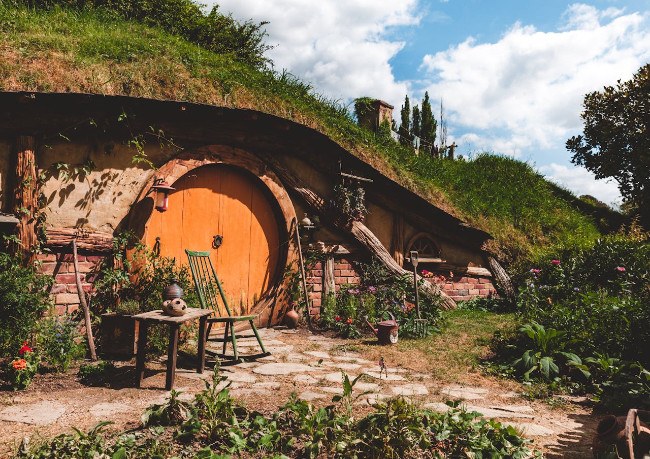 Explore a cozy hobbit house nestled in New Zealand's lush countryside, perfect for a rustic getaway.